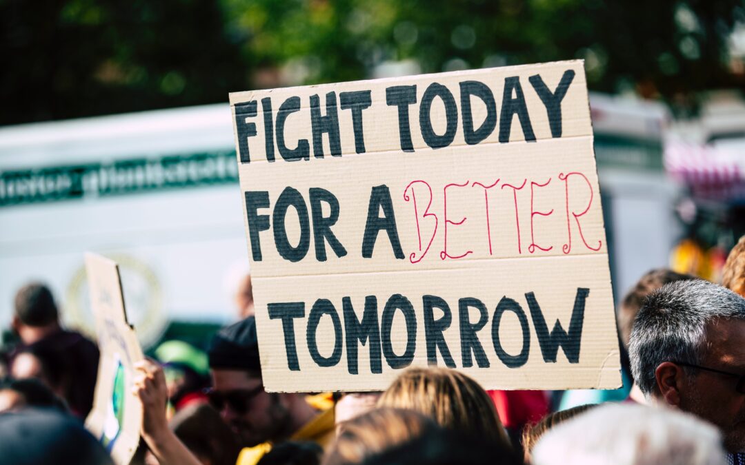 image of a protest with a sign that says "fight today for a better tomorrow"